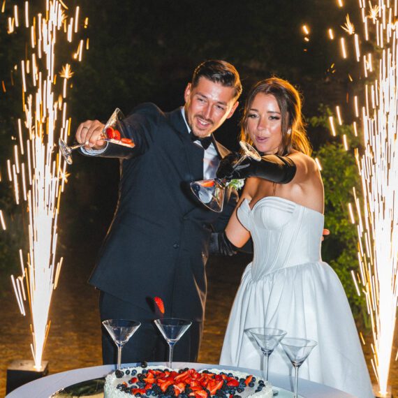 Brautpaar beim gemeinsamen Anschneiden der Hochzeitstorte